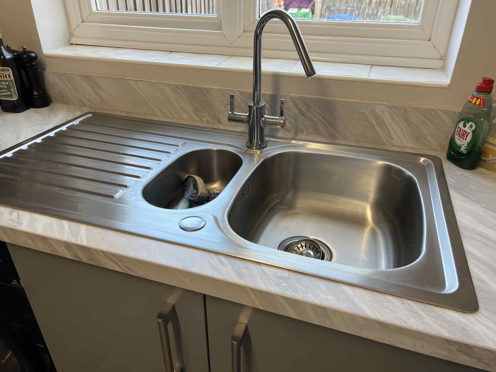 Empty, gleaming kitchen sink after cleaning