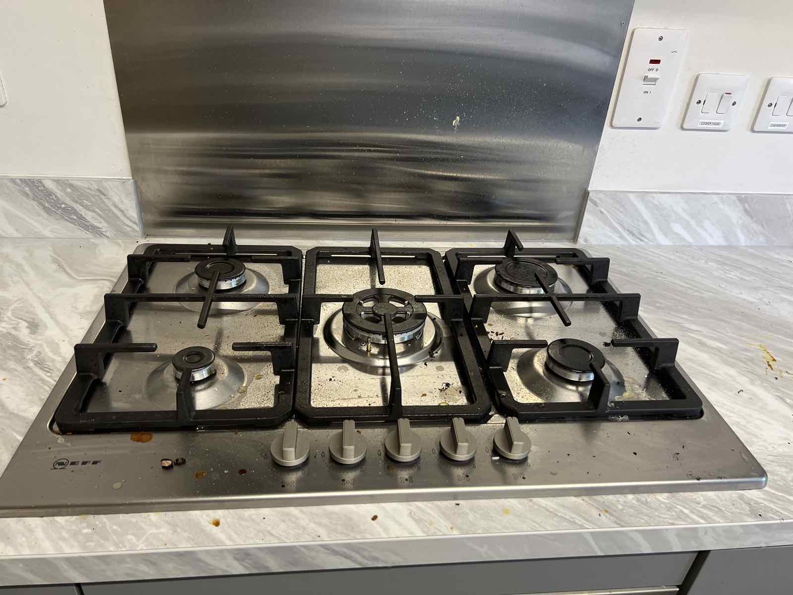 Greasy, splattered gas hob before cleaning